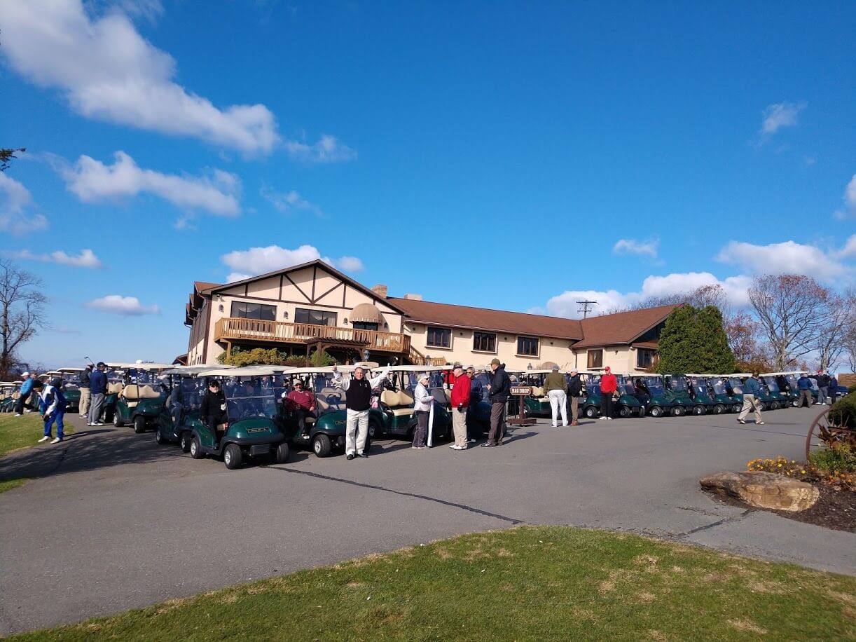 a photo of event attendees riding on hideaway hills golf carts